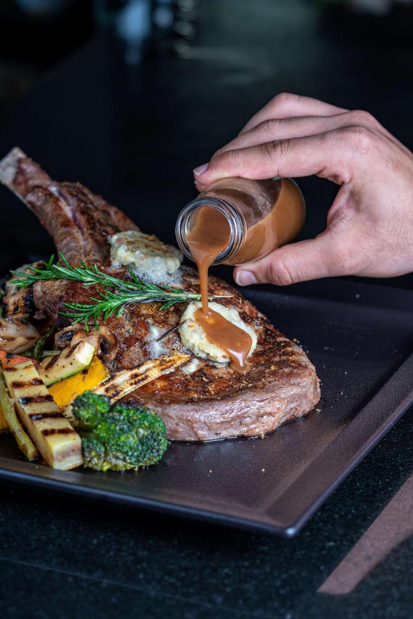 Radisson Blu Hotel & Resort, Sohar Exterior photo A steak being drizzled with a sauce